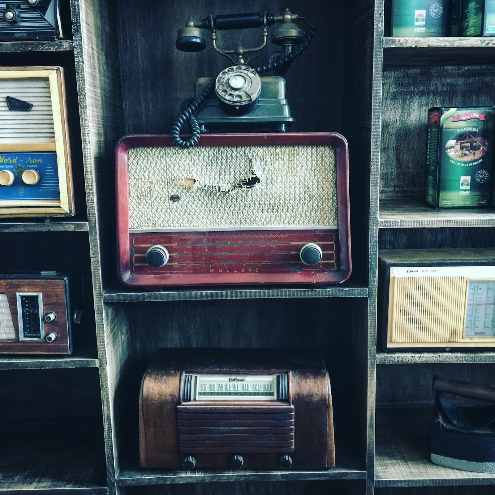 Vintage radios and telephones on wooden shelves